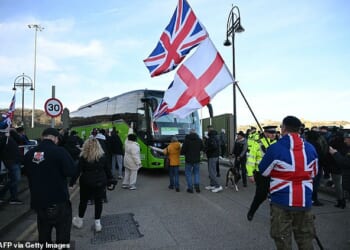 Protesters stop a coach as they gather outside a processing centre for migrants in Dover, Kent today