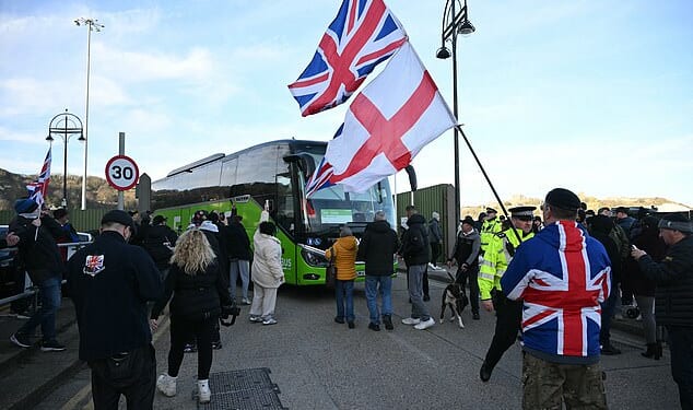 Protesters stop a coach as they gather outside a processing centre for migrants in Dover, Kent today