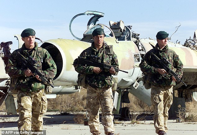 British marines hold rifles during a patrol at the Bagram air base near Kabul 19 December 2001
