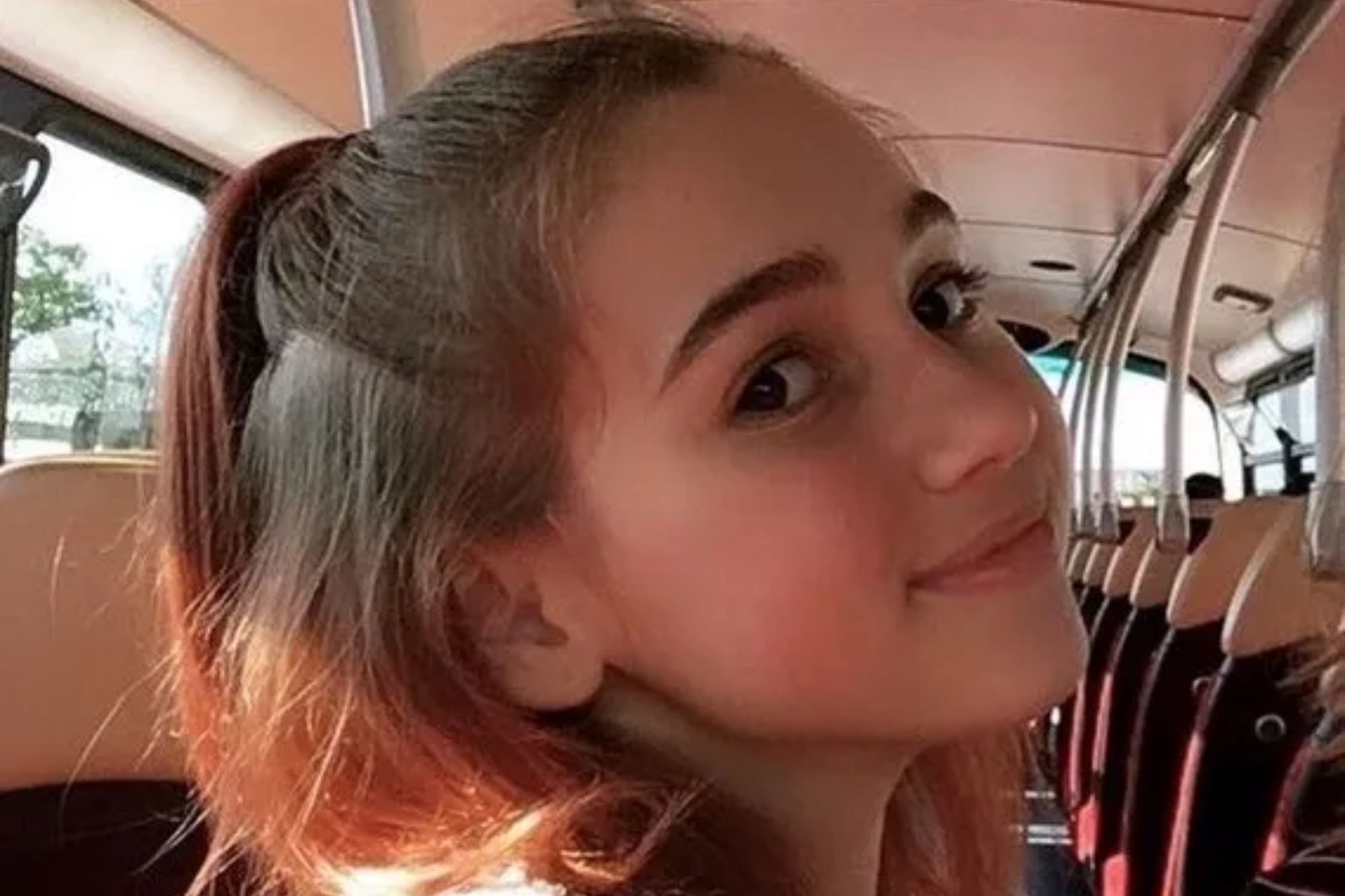 An image collage containing 1 images, Image 1 shows A young woman with light brown hair pulled into a ponytail smiles and looks back at the camera while riding in a vehicle