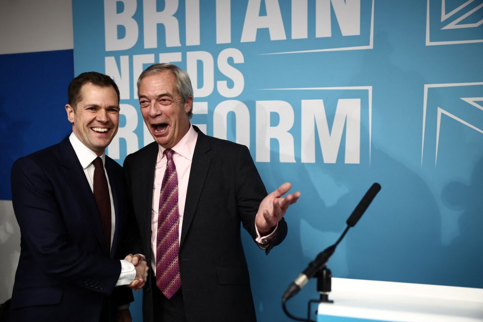 Robert Jenrick and Nigel Farage shaking hands at a press conference.