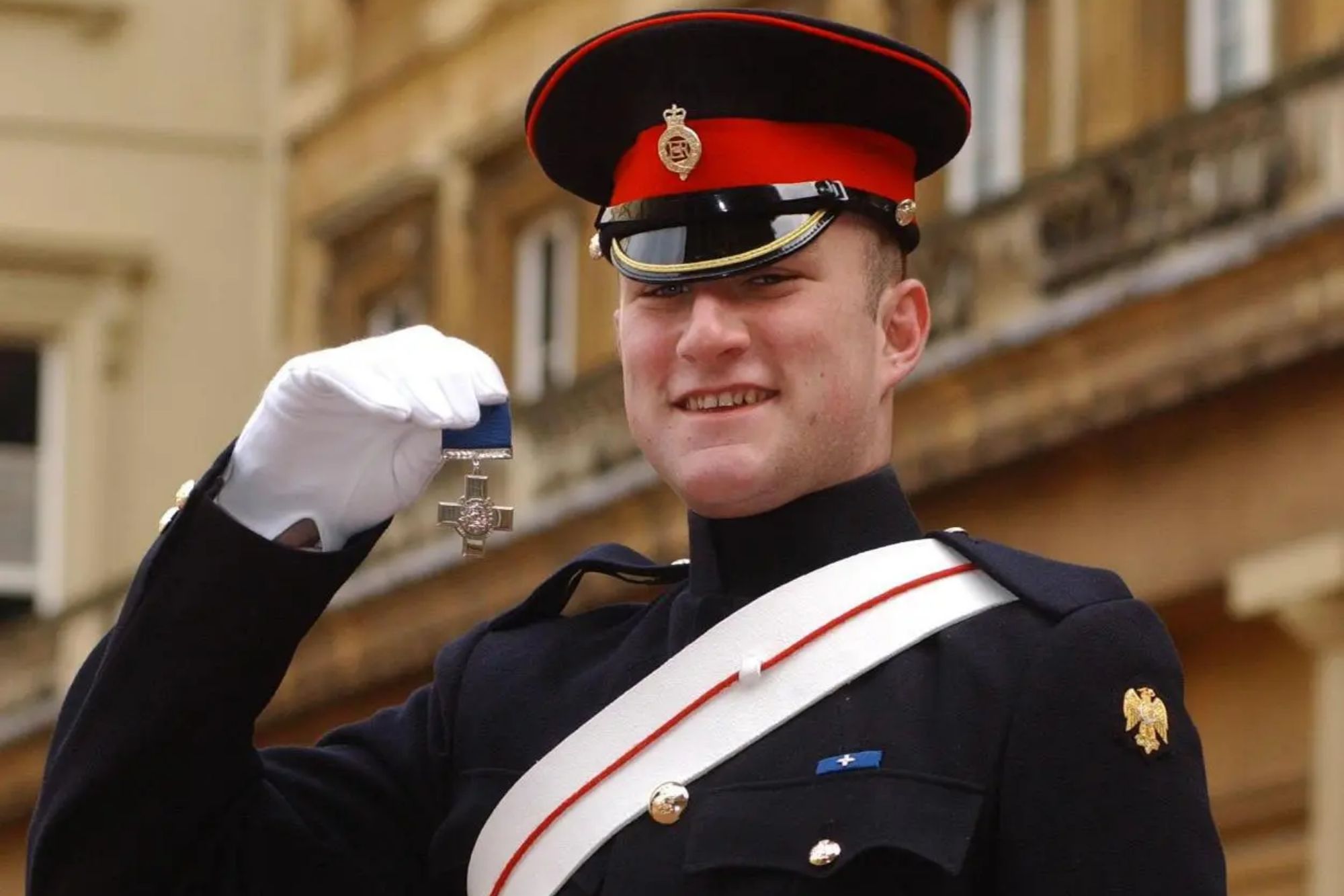 An image collage containing 1 images, Image 1 shows Christopher Finney wearing a military uniform and holding the George Cross medal