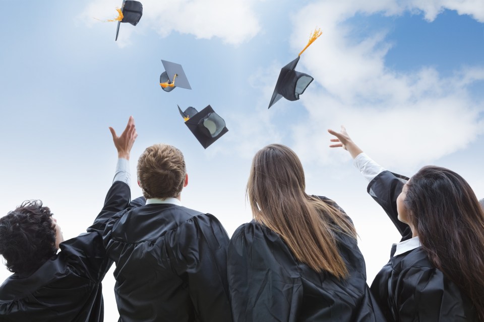Graduates throwing their caps into the sky.