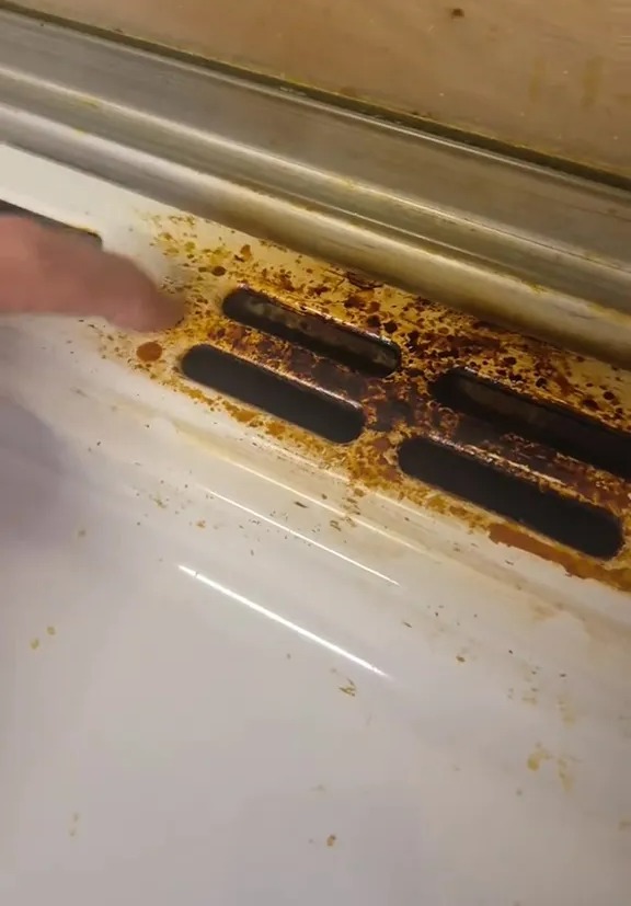 Rust and debris on a stovetop.