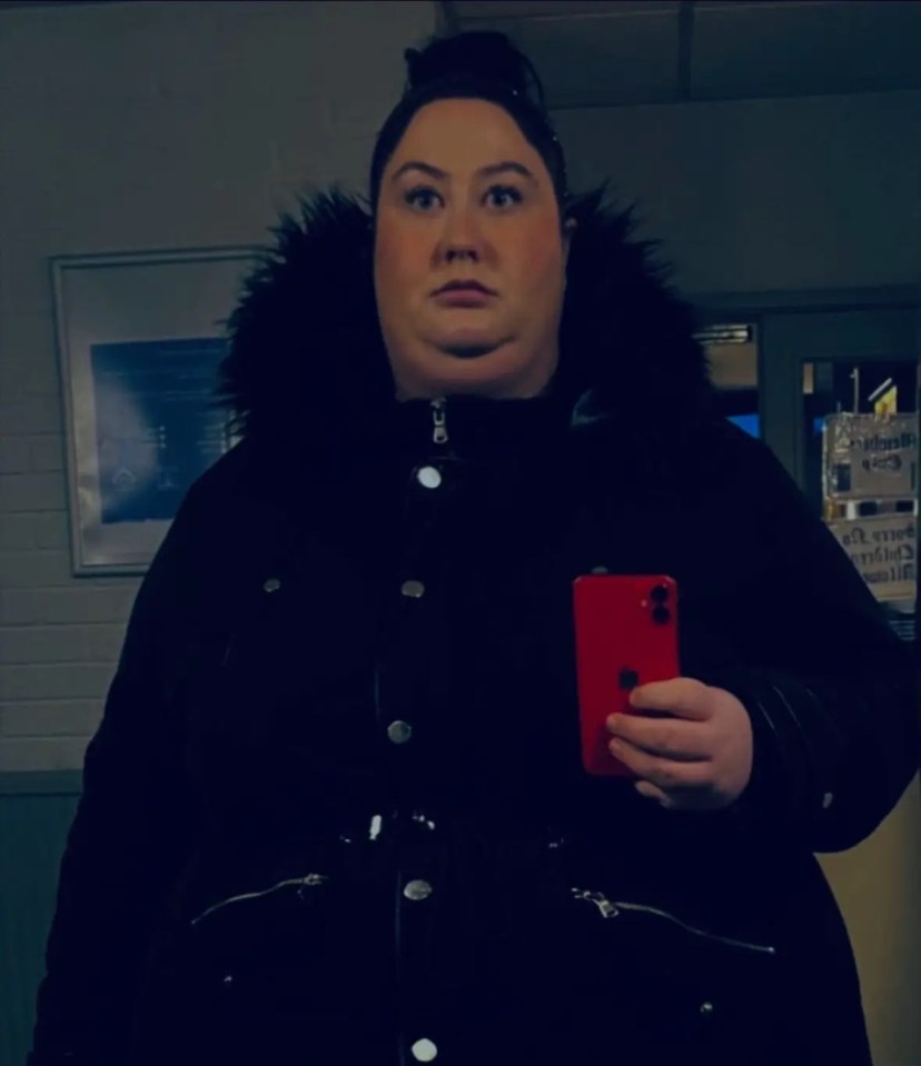 Woman in a black coat holding a red phone, with text overlay.