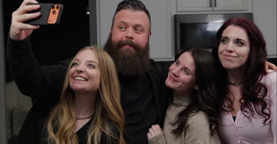 A man with a beard and three women take a selfie.