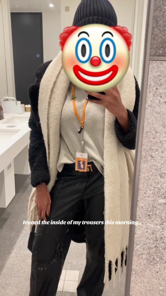 A person wearing a black beanie, a large clown emoji over their face, a white textured coat, a white top, and black trousers, with a visible "ironed the inside of my trousers this morning" text.