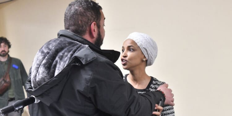 Rep. Ilhan Omar reacts after being sprayed with an unknown substance by a man as she hosted a town hall in Minneapolis, Minnesota, on Jan. 27, 2026.