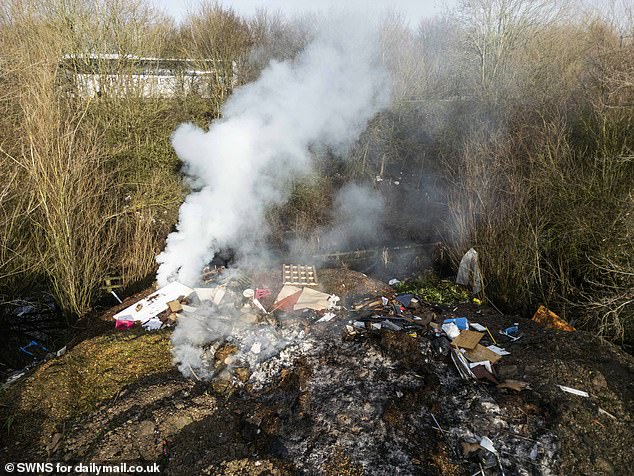 A smouldering pile of rubbish filmed by the Daily Mail during a visit to the site this week