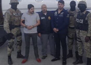 Efrain Campo Flores, second left, is seen with his cousin Francisco Flores de Freitas, third right, after their arrest in Haiti in November 2015 - still wearing their luxe loafers