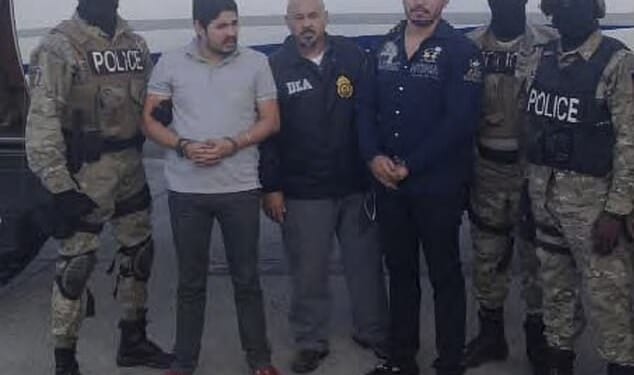 Efrain Campo Flores, second left, is seen with his cousin Francisco Flores de Freitas, third right, after their arrest in Haiti in November 2015 - still wearing their luxe loafers