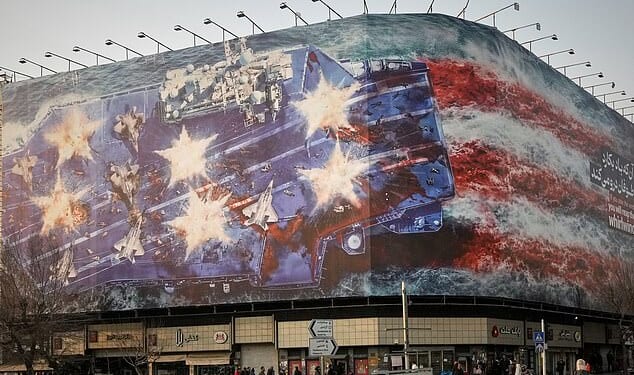 A billboard depicting a damaged US aircraft carrier with disabled fighter jets on its deck and a sign reading in Farsi and English, 'If you sow the wind, you'll reap the whirlwind,' is seen at Enqelab-e-Eslami (Islamic Revolution) Square in Tehran, Iran, Sunday, January 25