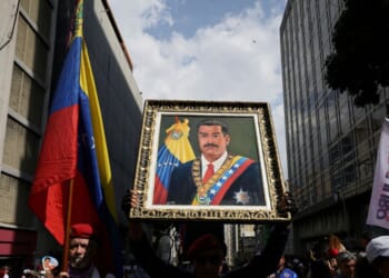 A man holds a portrait of Nicolas Maduro during a march in his support and his wife Cilia Flores after their capture by U.S. forces, on Jan. 6, 2026, in Caracas, Venezuela.