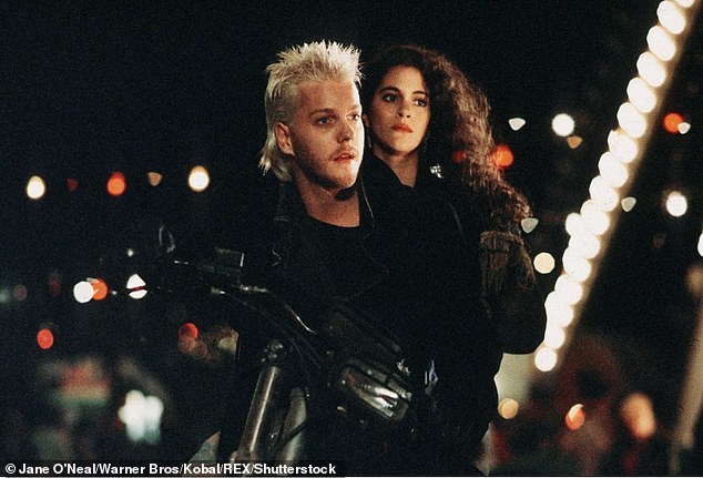 His profile increased substantially with Joel Schumacher's teen vampire film The Lost Boys (1987), and other early films included 1988's Young Guns, as well as Flatliners (1990), which paired him with Julia Roberts and Kevin Bacon; pictured in The Lost Boys with Jami Gertz