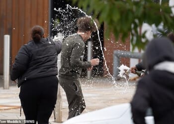 People spray sparkling wine over a man who walked out of Nottingham Prison on September 10, 2024 - the day the early release scheme came into effect