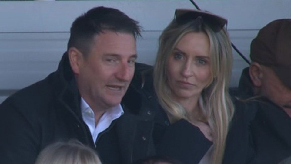 Man in dark coat with woman with long blonde hair.