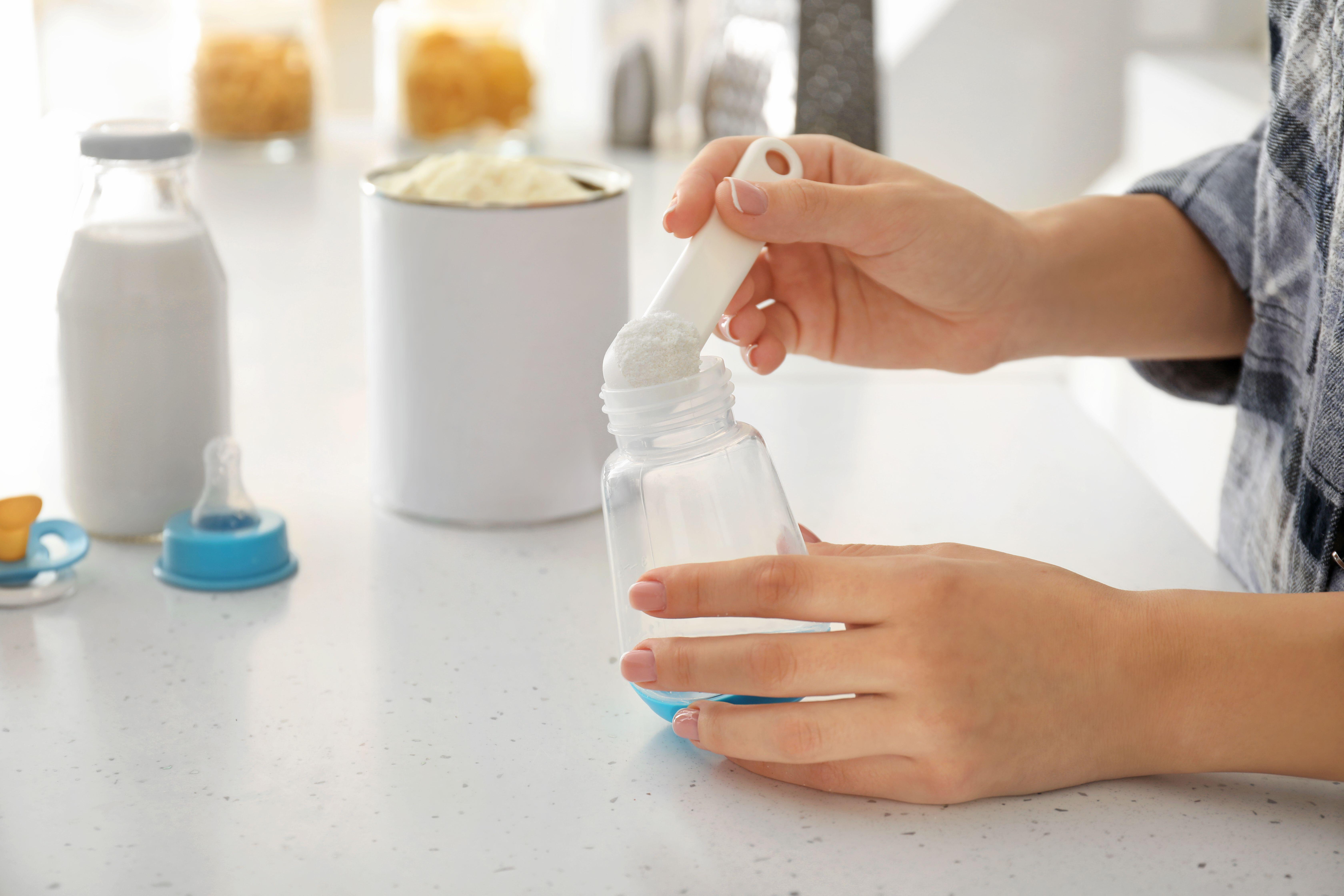 Woman preparing baby milk formula.