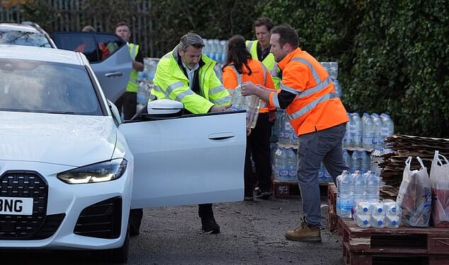 A worker hands out bottled water at the Tunbridge Wells Sports Centre on December 3