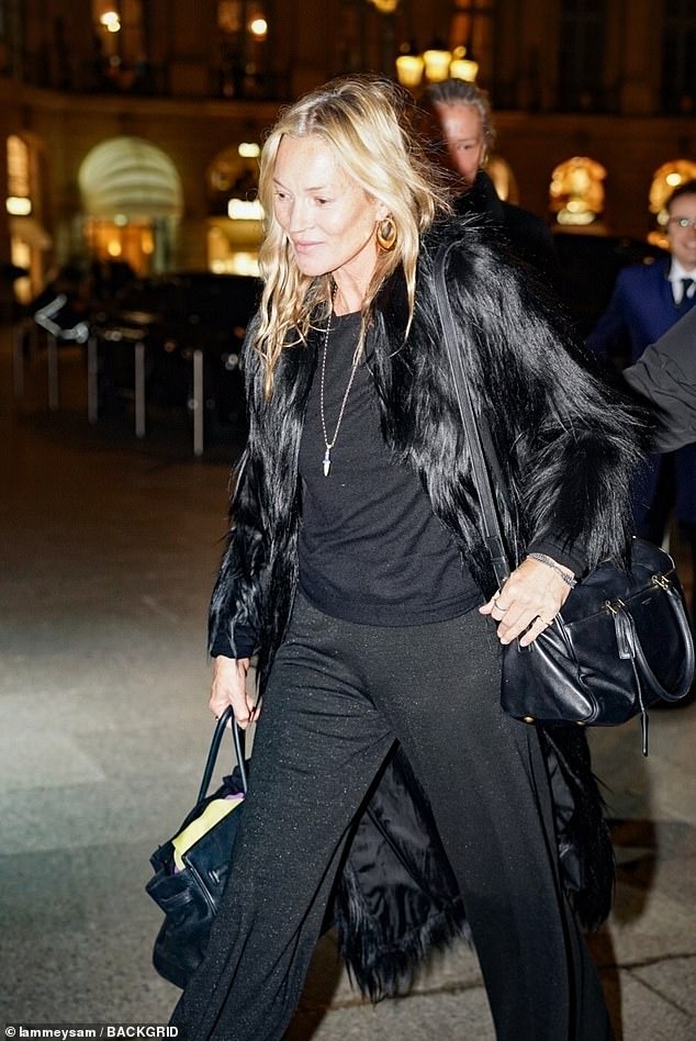 Carrying two handbags, the supermodel, 52, showcased her effortless style in a black furry coat, loose-fitting trousers and gold hoop earrings