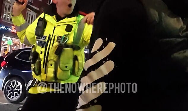 A police officer faces off with a man during clashes in Manchester this week as members of the Kurdish community protested events in Syria