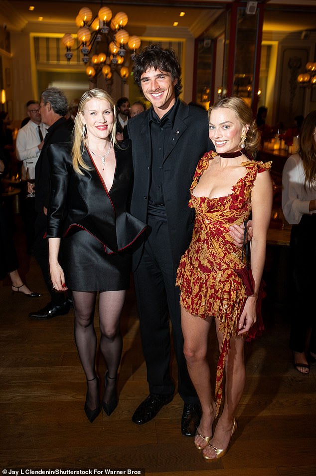 The low-cut dress flaunted Margot's cleavage, with playful ruffles along the sleeves and a hem that finished at her thigh, exposing her lithe legs. (Pictured: Wuthering Heights director Emerald Fennel and Jacob Elordi)