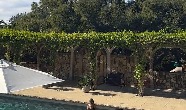 The sweet clips, uploaded to Instagram, show four-year-old Lilibet causing a splash in the water - accompanied by what appears to be Meghan's mother, Doria Ragland