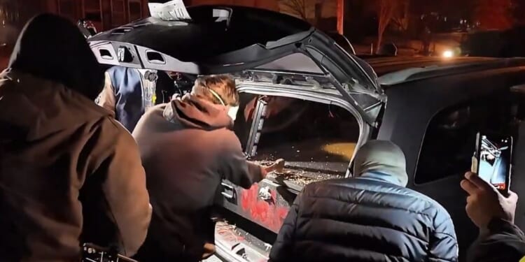 Minneapolis rioters held lights and cheered on their companion as he chopped his way into a gun safe with a hatchet.