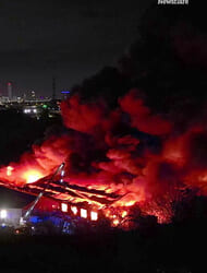 Moment warehouses burn in huge blaze as 50 firefighters battle inferno engulfing buildings & setting off explosions