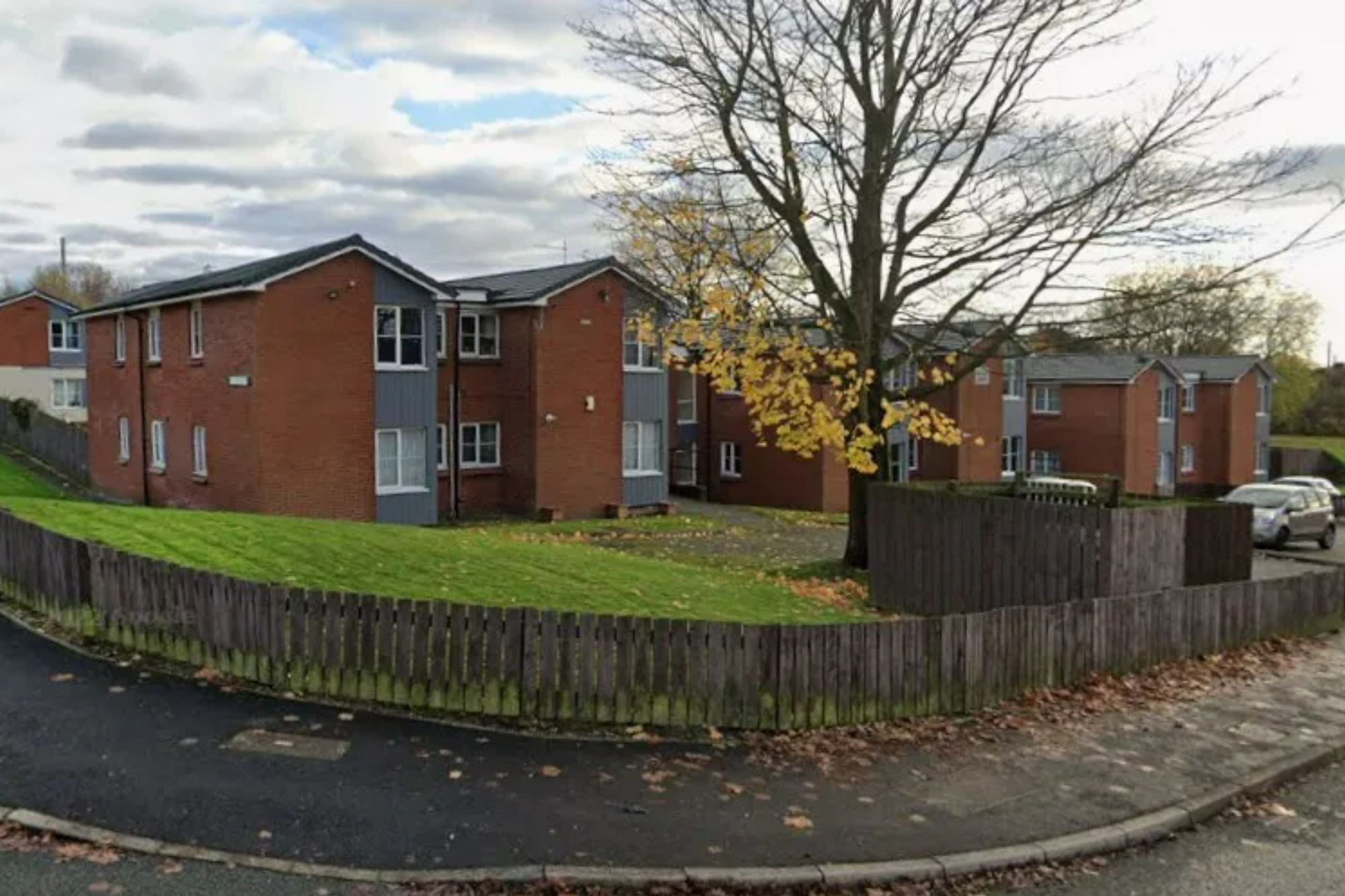 An image collage containing 1 images, Image 1 shows Gerards Court in St Helens, a residential area with red brick buildings, green lawns, and a wooden fence along the road
