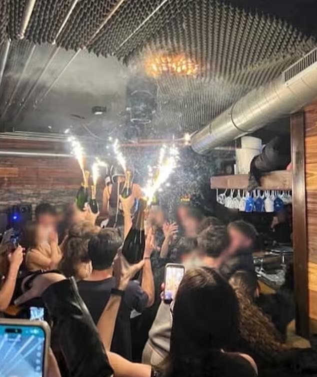A photo appears to show the moment champagne sparklers set fire to material on the ceiling of the Swiss nightclub