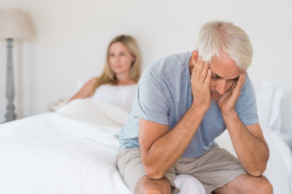 Upset senior couple ignoring each other in bed.