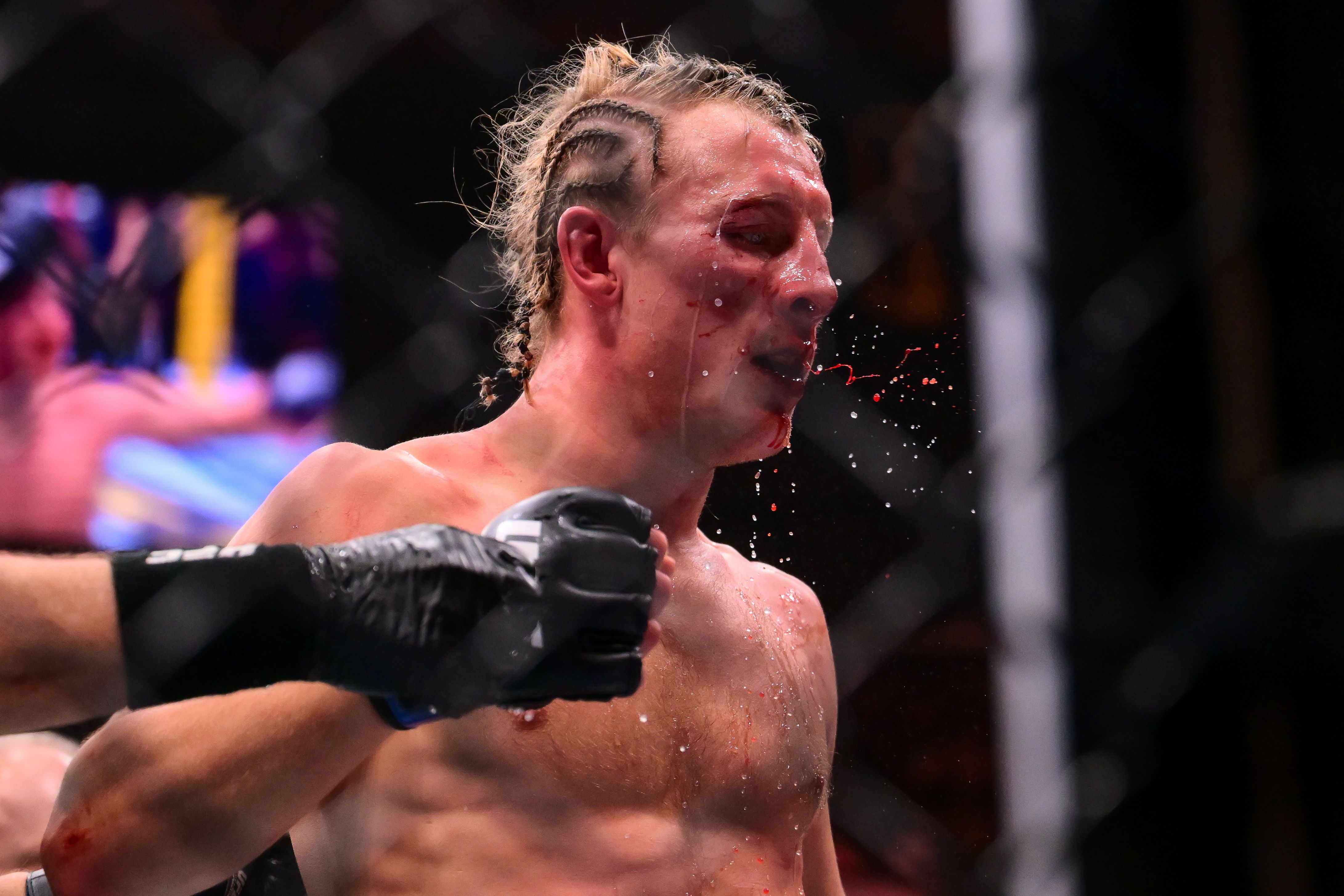 Paddy Pimblett with blood and water spraying from his face during UFC 324.