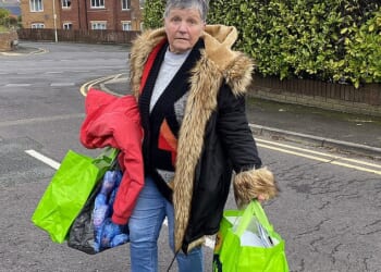 Jenny Field, 77, stands on the street with a few bags after she was evicted from her bungalow in Poole, Dorset