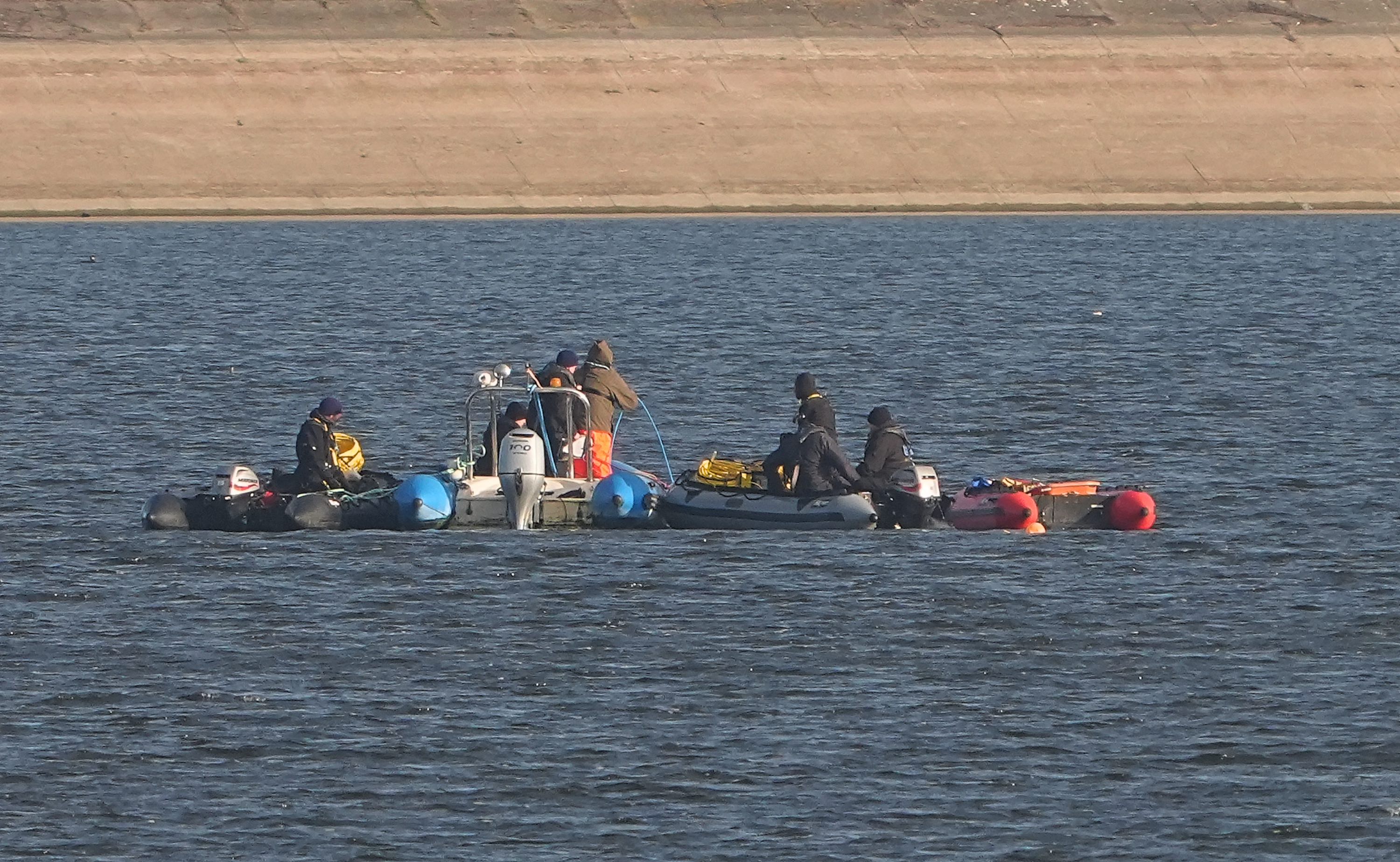 Boats recovering aircraft parts, including a seat cover and fiberglass, after a plane crash in Essex.