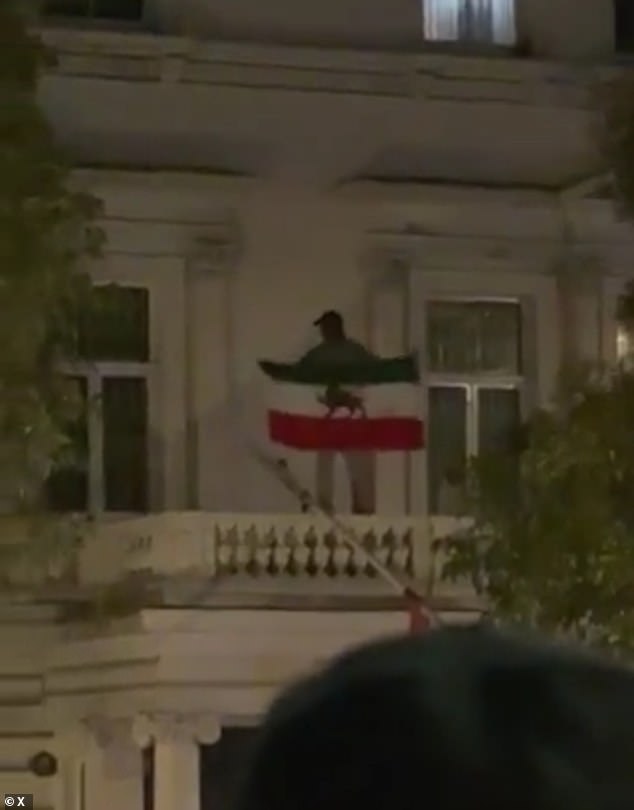 Protesters can be heard cheering as the man removes the flag