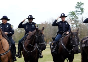 Police on horseback salute as the hearse carrying the flag-draped casket of former President George H.W. Bush heads to the Union Pacific train facility on Dec. 6, 2018, in Houston, Texas.