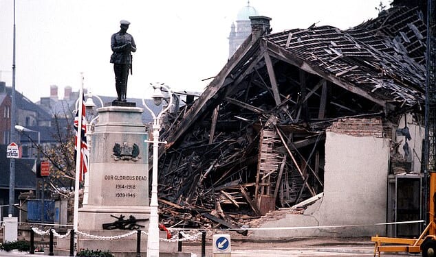 Cenotaph at Enniskillen with the devastated community centre in the background