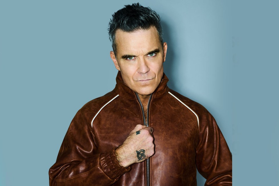 Robbie Williams in a brown leather jacket.