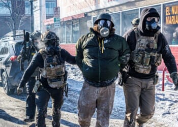 Federal agents detain a protester along a commercial street during clashes following the fatal shooting of a demonstrator earlier in the day, on Jan. 24, 2026, in Minneapolis, Minnesota.