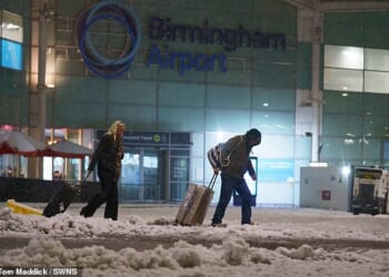 Holidaymakers battle d through the snow leaving Birmingham Airport after all flights were cancelled
