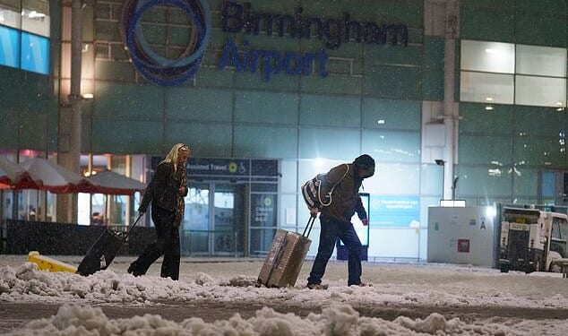 Holidaymakers battle d through the snow leaving Birmingham Airport after all flights were cancelled
