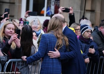 Prince William places his hand on Catherine's upper back as the pair posed for pictures in Scotland today