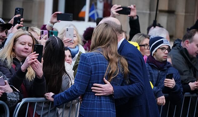 Prince William places his hand on Catherine's upper back as the pair posed for pictures in Scotland today