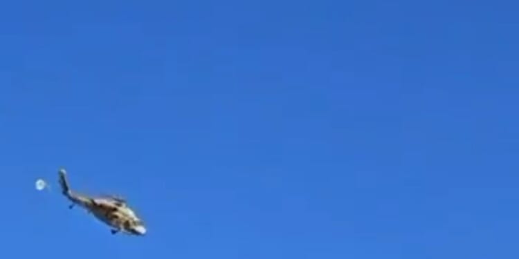 Terrifying moment helicopter being flown by second chopper breaks free and falls to the ground after harness failed