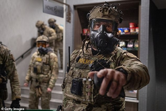 Federal agents enter the lobbly after breaking up a protest outside a hotel on January 25