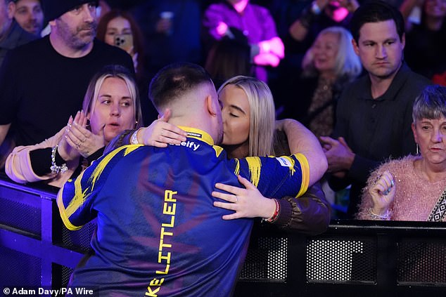 Littler shares a kiss with girlfriend Faith Millar during his walk-on on Friday night