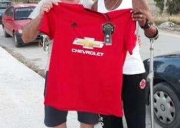 A man managed to dupe an entire Greek island that he was the legendary Manchester United player Remi Moses. Here he is pictured with a fan holding a United shirt in Zakynthos