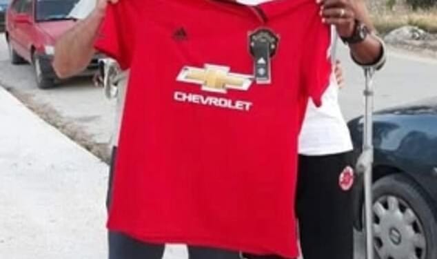 A man managed to dupe an entire Greek island that he was the legendary Manchester United player Remi Moses. Here he is pictured with a fan holding a United shirt in Zakynthos