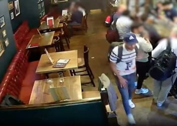 Phone thief Aouidj Abderaouf walks past a rucksack that he later made off with. The bag is pictured in the bottom left of this video grab