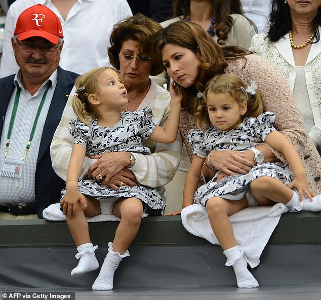 The twin sisters watch as their dad wins the 2012 Wimbledon final with mum Mirka (right)